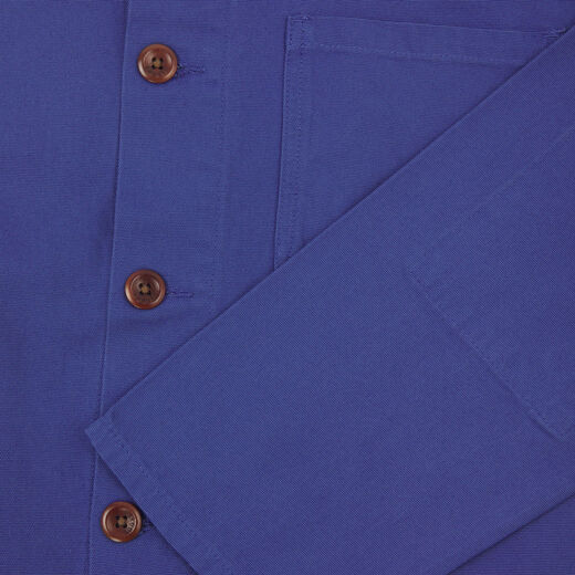 Detail of a blue overshirt with a close up on three brown buttons.